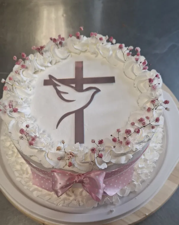 Torta s križem i golubicom i ružičastom mašnom