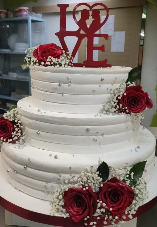 Svadbena torta s crvenim ružama i natpisom LOVE