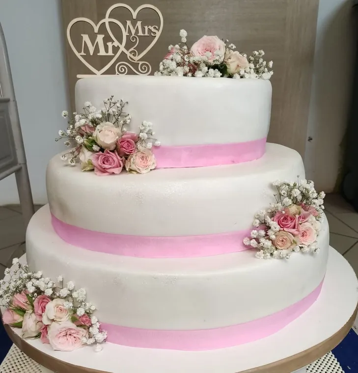 Svadbena torta na tri kata s ružičastim cvijećem i natpisom Mr & Mrs